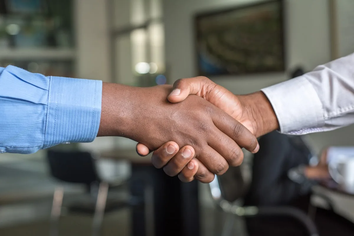 Business handshake representing the moment a SaaS company sale closes and post-close obligations begin