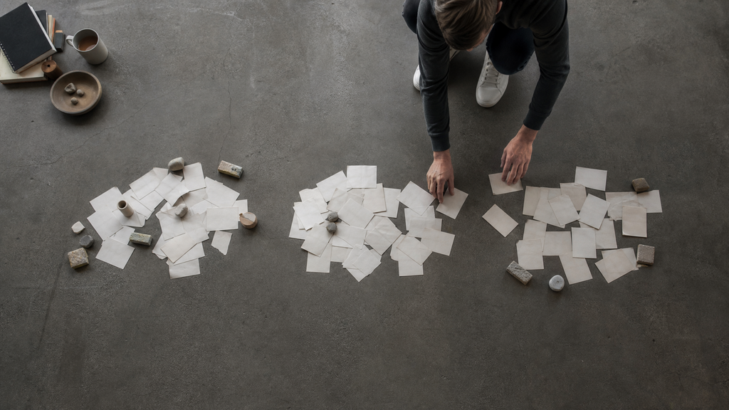 Overhead view of paper slips being sorted into piles, representing buyer diligence on SaaS LTV CAC ratio inputs