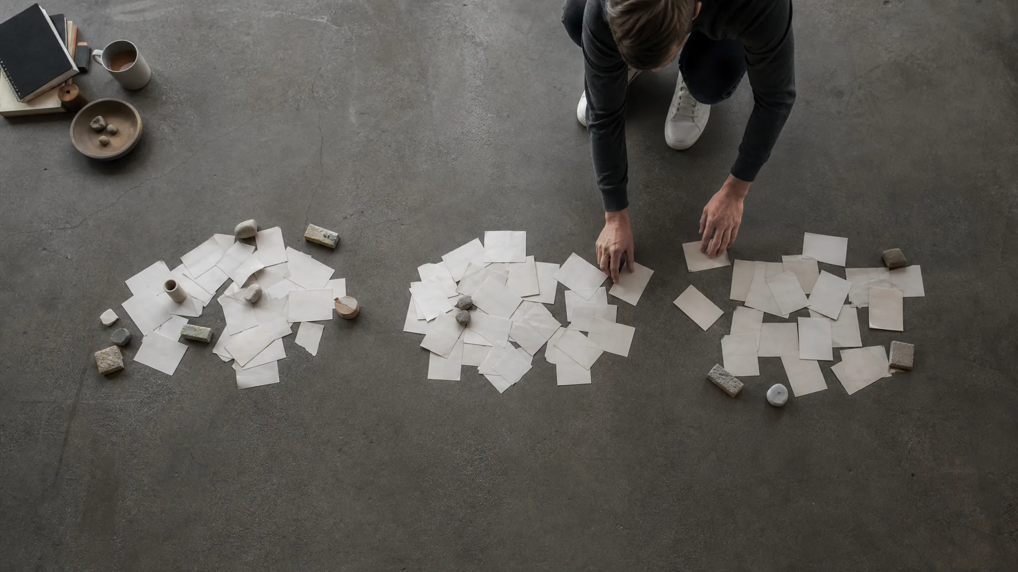 Overhead view of paper slips being sorted into piles, representing buyer diligence on SaaS LTV CAC ratio inputs
