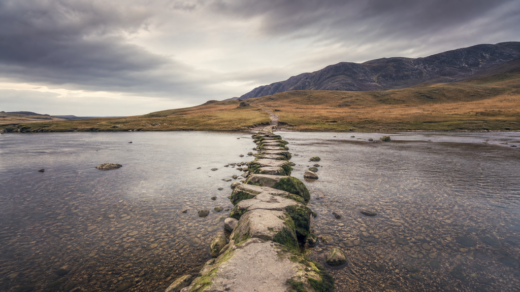 Shallow river crossing toward higher ground, representing SaaS valuation with negative EBITDA and the path to future cash flow