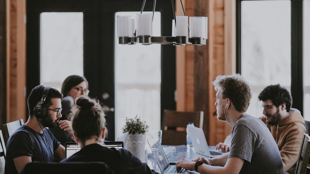 SaaS team working together before an acquisition, representing key employee retention and stay bonuses